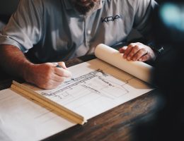 An architect working on a draft with a pencil and ruler