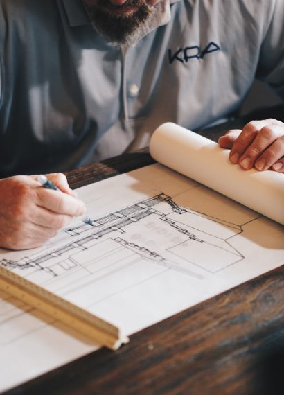 An architect working on a draft with a pencil and ruler