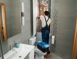 A plumber repairs plumbing in a bathroom.