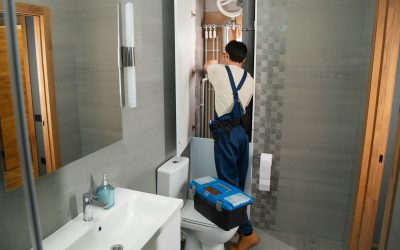 A plumber repairs plumbing in a bathroom.
