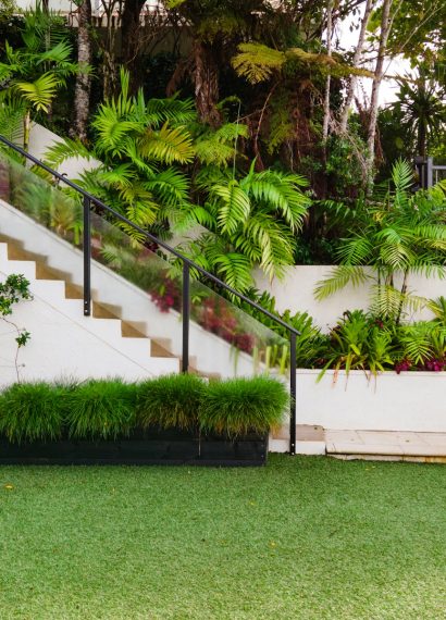 a white house with a green lawn and stairs