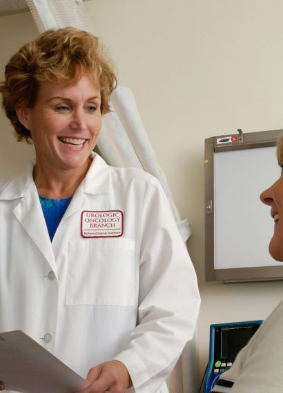 woman in white scrub suit holding gray laptop computer