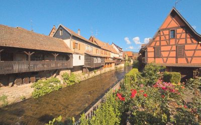 a river running through a village next to tall buildings