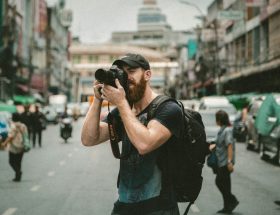 shallow focus photography of man using a DSLR camera