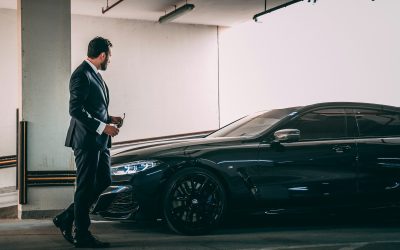 a man in a suit standing next to a car